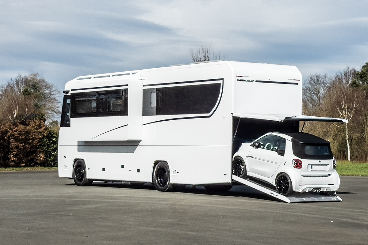 Photo of the VARIO Perfect 1000 comfort motorhome on MB Actros, high-gloss white and Blackline Edition with black Gals window strip, black rims and Brabus SMART convertible in the car garage