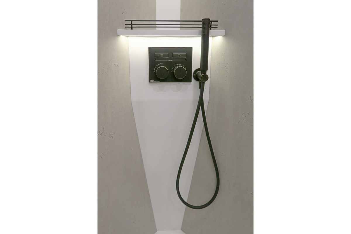 Das Foto zeigt eine indirekt beleuchtete Dusch-Konsole in Betonoptik mit schwarzer Gessi-Design-Thermostat-Armatur in der VARIOmobil-Landyacht VARIO Perfect 1050